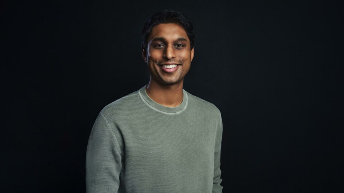 Ankur Jain smiles in a green long sleeve shirt