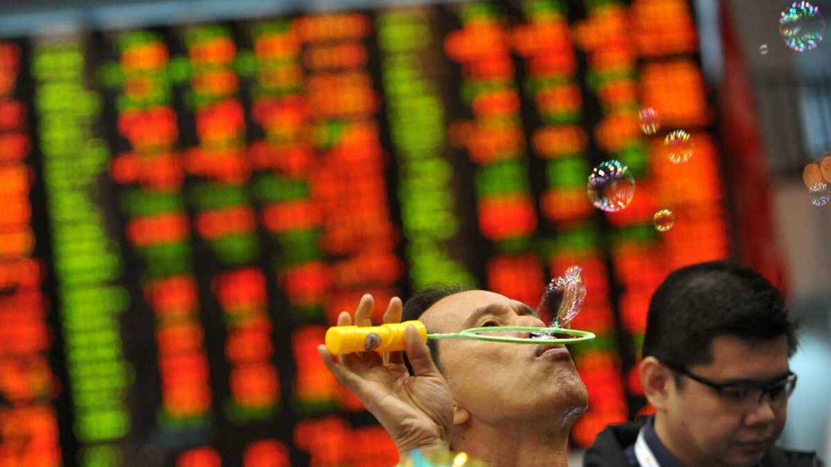 A trader blows bubbles during the year-end closing of trade in front of a giant electronic board at the Philippine Stock Exchange in Manila on December 30, 2010.