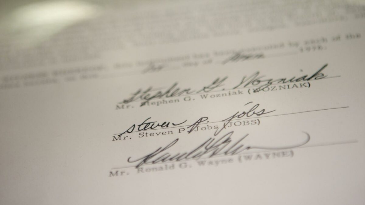 Photo of three signatures at the bottom of a contract