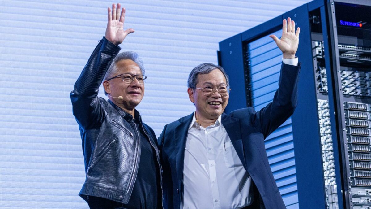 two men waving in front of server racks
