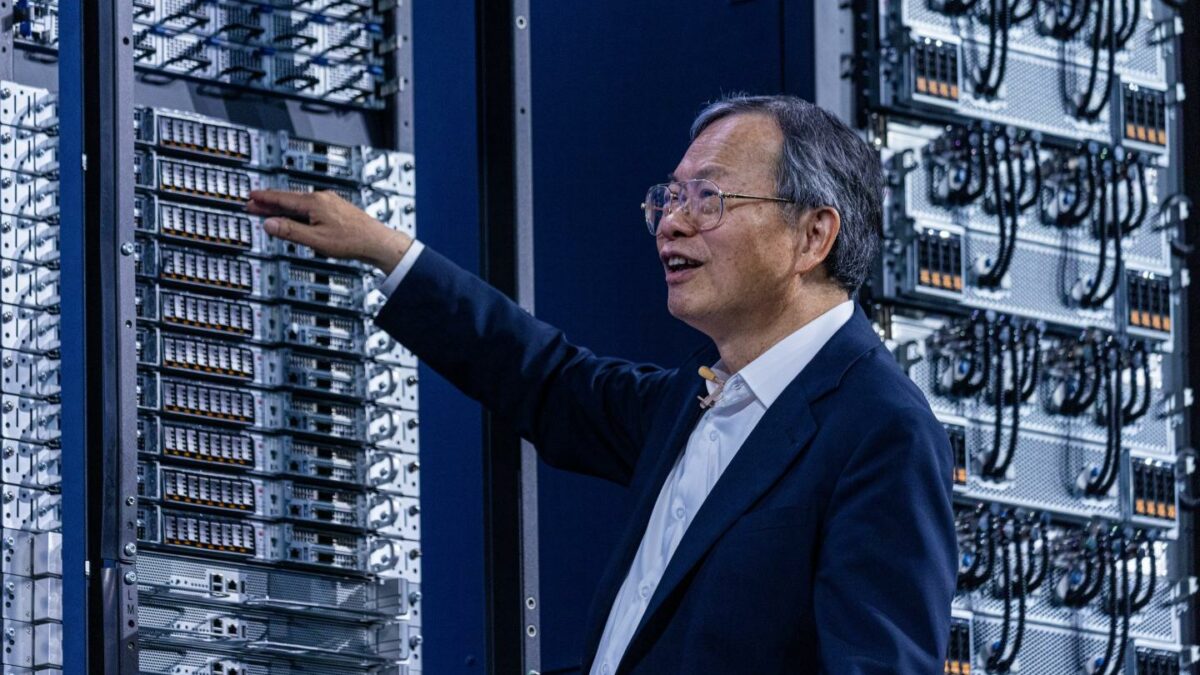 Man in a suit touches servers in a rack.
