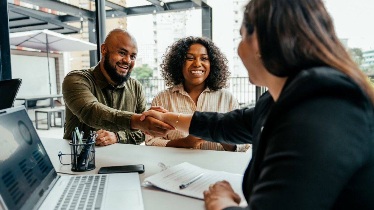 A couple meeting with someone at a bank.