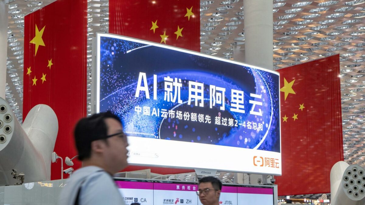 Travelers walk past an Alibaba Cloud advertisement in China