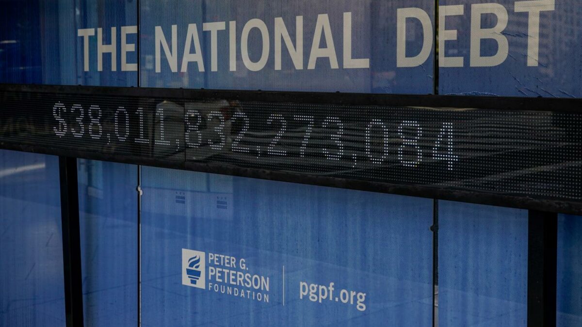 A bus shelter with an electronic billboard and a poster display the U.S. debt on Oct. 28, 2025, in Washington, D.C.