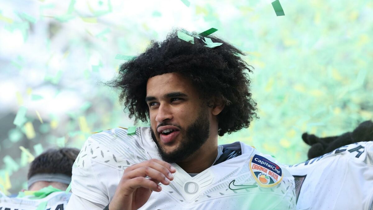 Dante Moore reacts to green and white confetti falling on him.