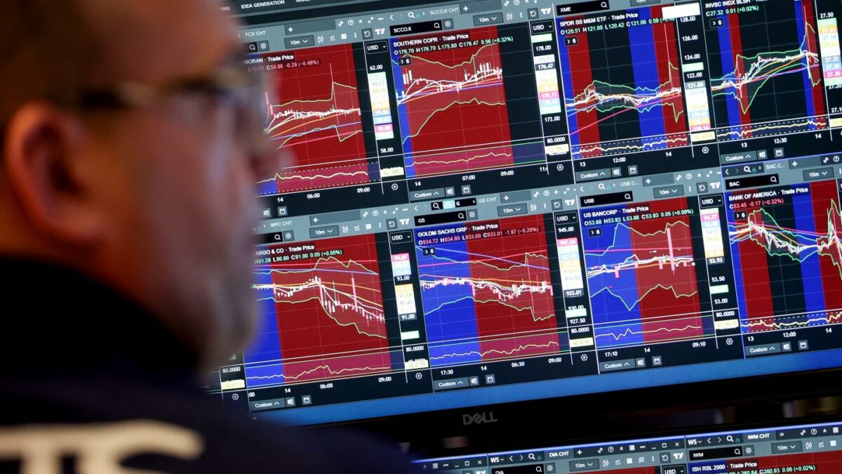 A trader works at his desk on the floor of the New York Stock Exchange on January 14, 2026.