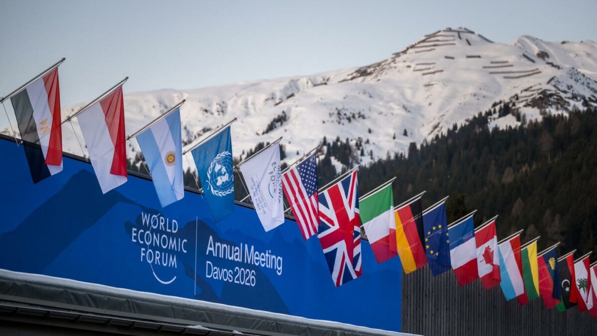 Image of various nation's flags over the World Economic Forum sign in Davos.
