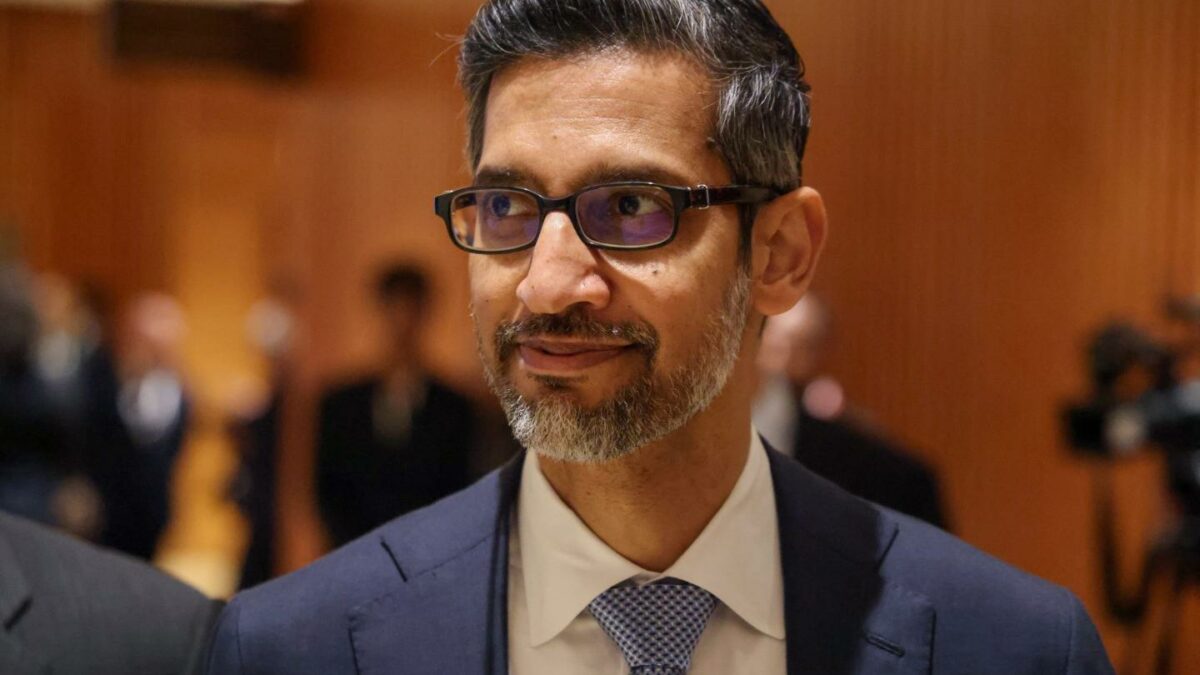 Man in glass and a suit looking to the side.