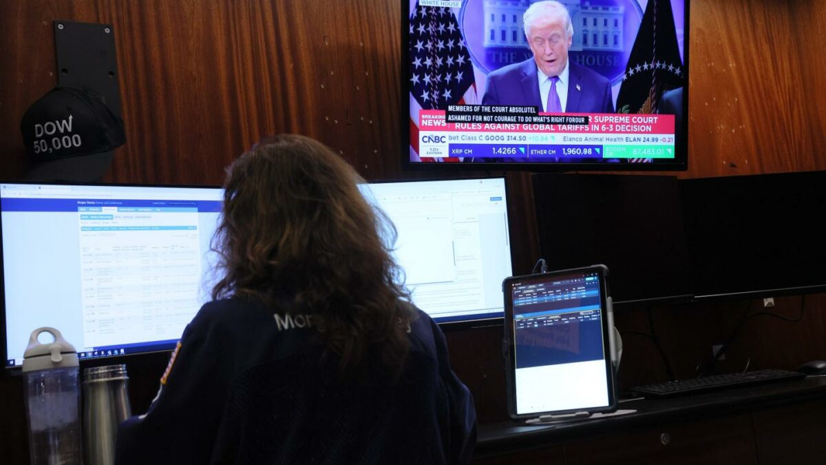 A woman works as President Donald Trump's speak on the television in front of her.