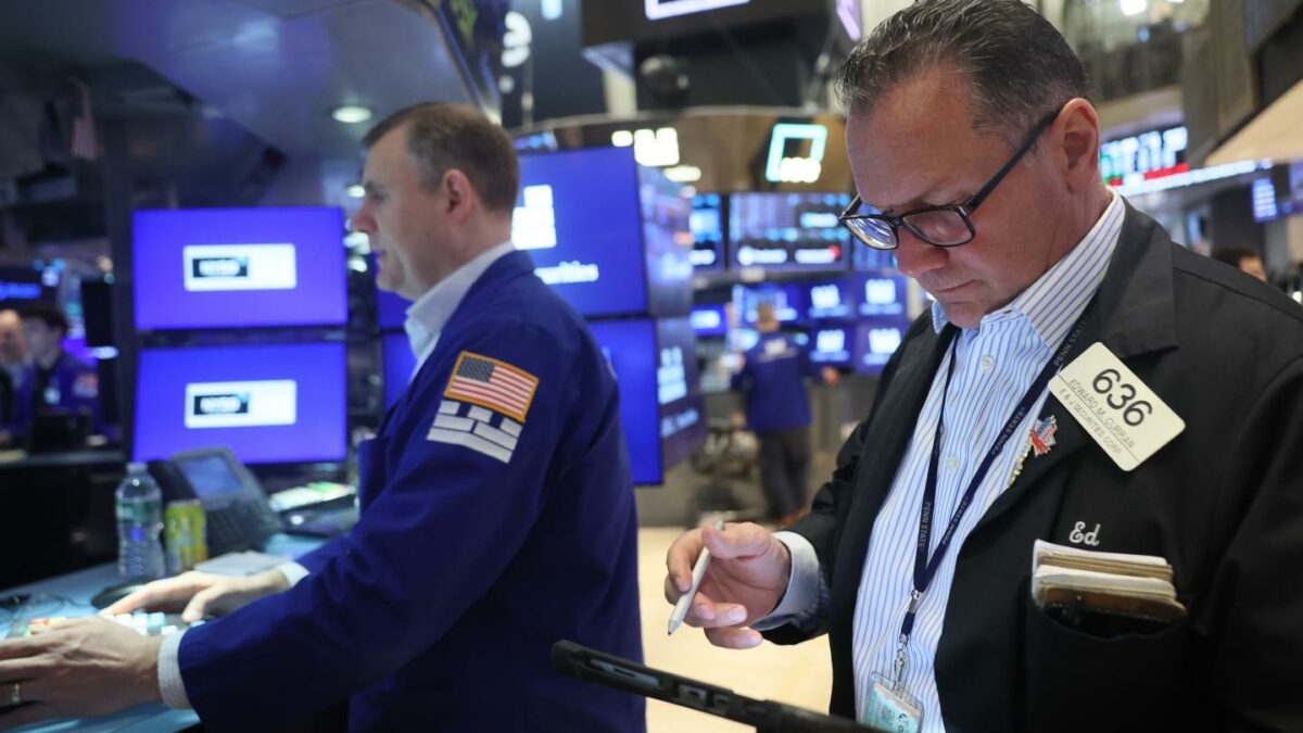 Traders stand at the New York Stock Exchange