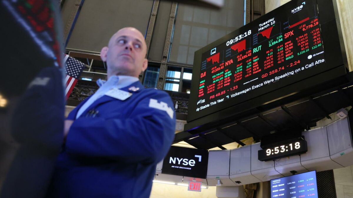 Stock market numbers are displayed as traders work on the floor of the New York Stock Exchange