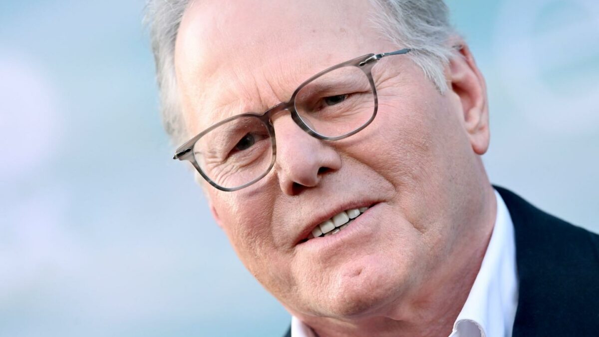 Man with glasses in a suit smiling