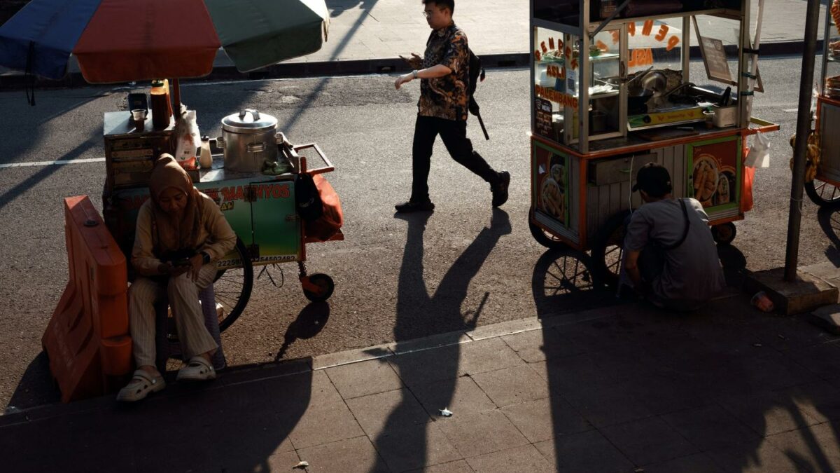 A pedestrian passes street food stalls in the central business district in Jakarta, Indonesia, on Friday, June 19, 2026.
