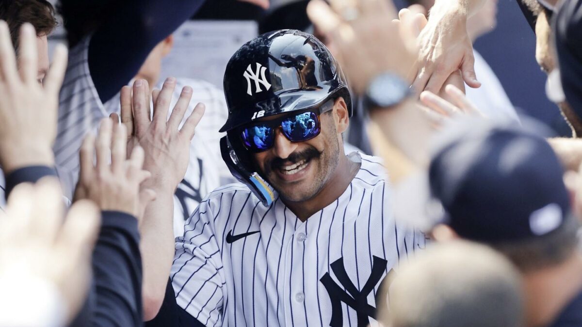 Trent Grisham #12 of the New York Yankees celebrates his eighth inning home run against the Atlanta Braves with his teammates in the dugout.