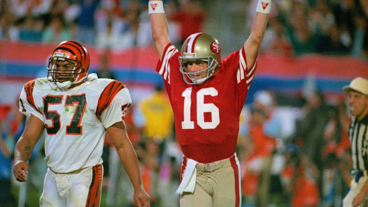 Joe Montana raises his arm in celebration after throwing a touchdown pass to Jerry Rice.