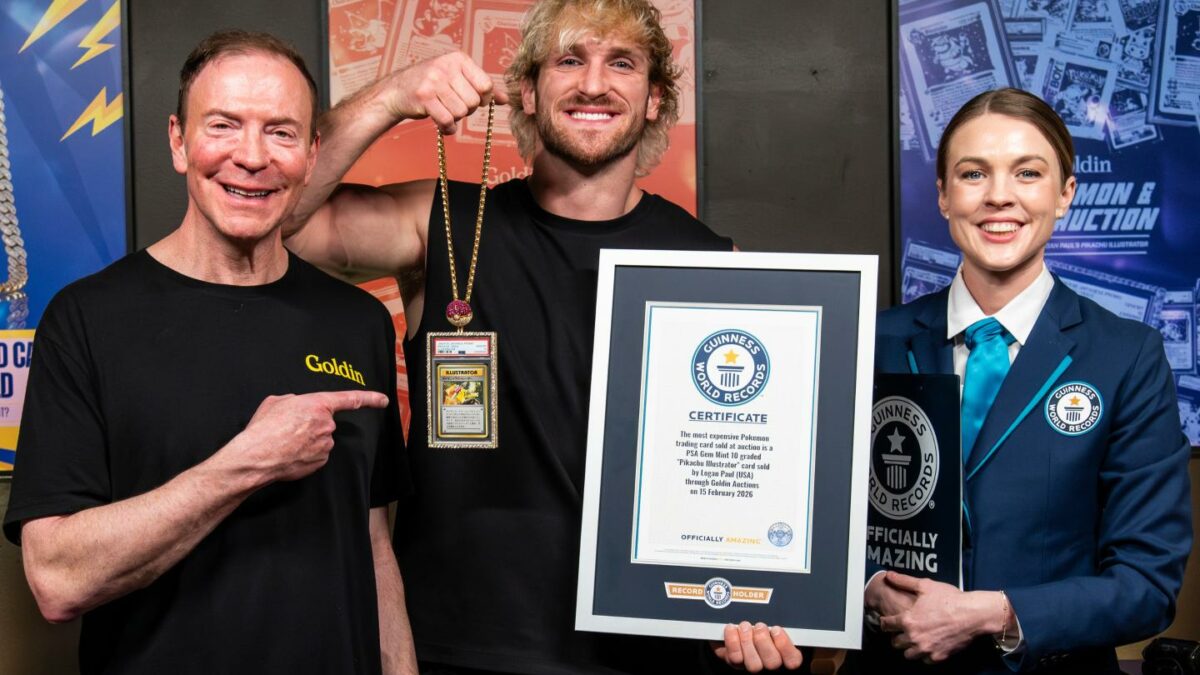 Ken Goldin, Logan Paul, and a Guinness World Record woman stand with Paul's Pokemon card