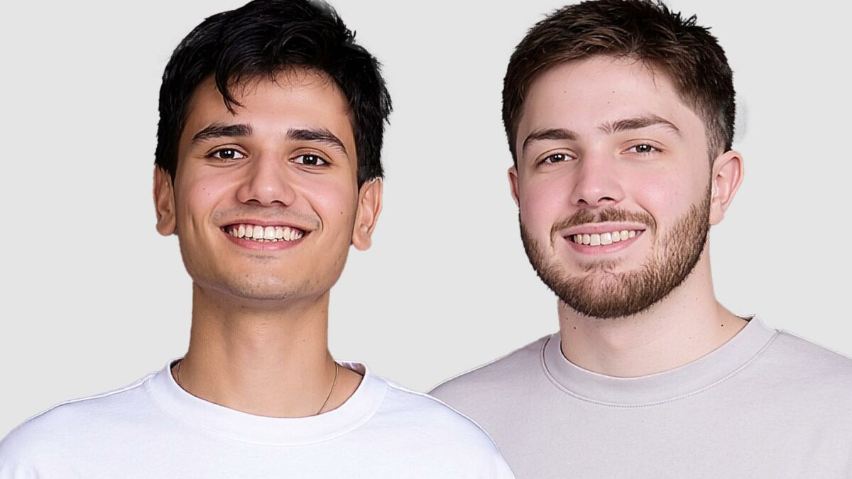 two men smile in front of the camera